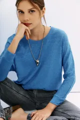 Remera de algodón peruano jaspeado, con moldería holgada y mangas largas que se ajustan en la muñeca.