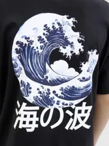 Remera negra de algodón con cuello redondo y mangas cortas. Estampado en la espalda con una ola estilo arte japonés y texto en caracteres orientales.