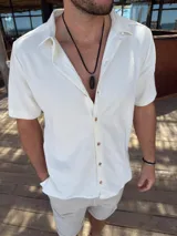 Camisa blanca de manga corta con textura waffle y cuello clásico.