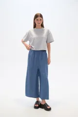Pantalón capri de denim azul con cintura elástica y aberturas laterales en el ruedo.