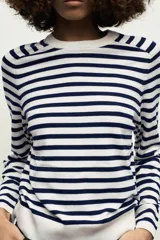 Jersey de punto color crema con rayas horizontales azul marino, de cuello redondo y manga larga.