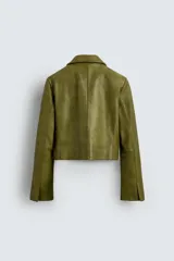 Blazer corto de cuero color verde oliva, con cuello con solapas de pico, manga larga con puños con abertura, bolsillos de solapa en la cintura, efecto vintage y cierre frontal con botones.