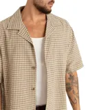 Camisa beige a cuadros con cuello solapa, manga corta y cierre con botones.