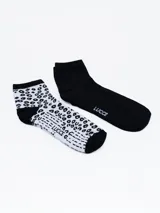 Pack de dos pares de medias cortas, un par negro liso con logo lateral y un par blanco con estampado animal print en negro.