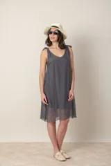 Vestido corto negro de seda con breteles finos anudados en los hombros y escote en V.