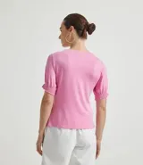 Blusa de viscolycra color rosado, con cuello redondo y mangas cortas abullonadas con puños de lastex.