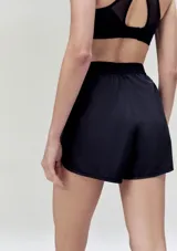 Short deportivo negro con cintura elástica y logo pequeño en la pierna.