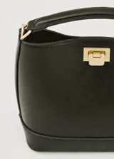 Bolso tipo bucket negro de cuero sintético con asa corta y cierre metálico dorado.