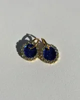 Aros colgantes con forma circular, con centro de resina azul con glitter, borde dorado con strass y arito de acero quirúrgico dorado.