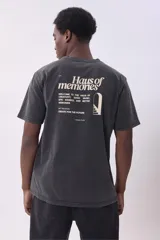 Remera gris oscuro con efecto lavado, cuello redondo y logo pequeño bordado en el pecho.