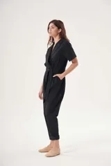 Mono celeste de corte cruzado con cuello camisero, mangas cortas, bolsillos laterales y cinturón de lazo.