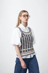 Top tejido sin mangas con diseño geométrico de rombos en relieve, en tonos azul marino y beige. Presenta escote amplio y breteles tejidos.