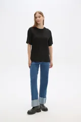 Remera negra de viscosa con textura acanalada, corte holgado y cuello redondo.