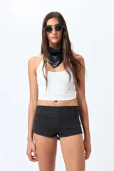 Microshort de tiro bajo color negro, con cierre metálico en la espalda, de calce ajustado y largo mini.