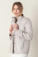 Campera roja de cuero ovino italiano, con charreteras en los hombros, bolsillos laterales, broches ocultos en el frente y broches a la vista en cuello y puños.