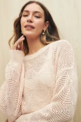 Sweater calado color blanco de punto liviano con diseño geométrico, silueta relajada y terminación en rib en cuello, puños y ruedo.