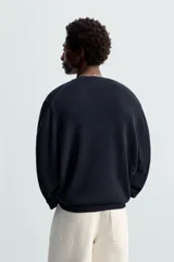 Jersey azul marino de punto, con cuello redondo y manga larga. Tejido en hilatura con mezcla de seda y lino.