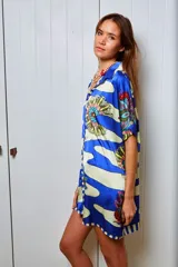 Camisola estampada en seda, con cuello camisero, manga corta y calce holgado. Presenta un diseño con rayas horizontales y flores. Puede usarse como camisa o vestido.