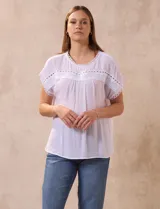 Blusa blanca de gasa marca Palm Rio, con cuello a la base y manga corta japonesa. Aplique de crochet en cuello, ruedo de manga y delantera.