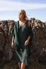 Vestido tejido de punto color verde oscuro, largo midi, con escote en V y sisa profunda. Presenta un calado con textura diagonal en la parte inferior de la falda.