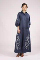 Camisa azul marino con bordados de flores blancas en mangas y ruedo.