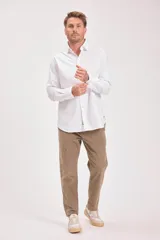 Camisa blanca de manga larga con cuello clásico y cierre frontal con botones.