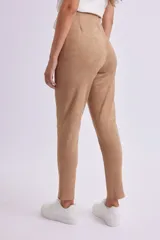 Calza de gamuza color beige, de tiro alto y corte ajustado.