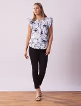 Blusa de algodón estampada con flores en tonos celeste y azul, marca Cable & Gauge. Cuello a la base, escote en V y abertura central con botones. Sisa con volados.