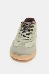 Zapatillas deportivas color verde oliva con detalles en rosa y marrón.