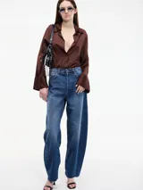 Pantalón denim azul de corte amplio, tiro alto, con bolsillos delanteros y traseros, y terminación desflecada en el bajo.