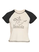 Remera color crema con mangas cortas negras tipo ranglán y estampado de jinete con la palabra 'Bandida'.
