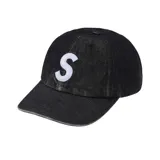 Gorra negra de denim con logo "S" bordado en blanco en el frente.