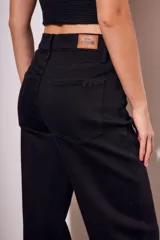 Pantalón de jean negro de corte wide leg y tiro medio.