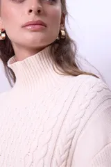 Sweater de punto color borgoña con cuello alto y diseño trenzado.