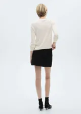 Sweater de punto fino color beige, con cuello redondo y mangas largas.