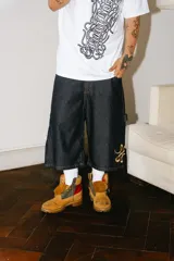 Bermuda carpintera de jean azul oscuro, corte baggy, con bordado dorado en el lateral, bolsillos grandes, bolsillo lateral y tira carpintera lateral.