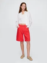 Short de jean color rojo, corte a la rodilla.