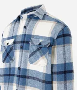 Campera trucker masculina de terciopelo a cuadros en tonos azul, blanco y beige. Tiene cuello inglés, cierre abotonado, bolsillos delanteros y laterales.