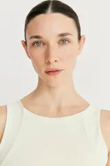 Top deportivo color crema, de cintura ancha y compresión suave, con recortes en el delantero.