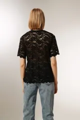 Top negro de encaje con mangas cortas, cuello redondo y corte holgado.