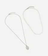 Set de dos collares: uno con cadena de eslabones plateada y medalla de la Virgen María, y otro con perlas artificiales.