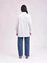 Camisa blanca de manga larga con detalles de encaje en los hombros.