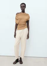 Pantalón de lino color beige, de corte recto, con cintura elástica ajustable con cordón.