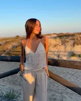 Top blanco con lentejuelas, escote en V y tirantes finos.