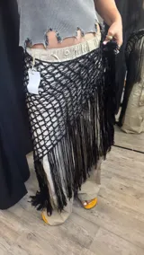 Pareo artesanal tejido a mano en hilo de seda viscosa, color negro, con diseño de red y flecos largos en el borde.