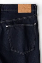 Pantalón de jean azul oscuro, de corte recto y tiro medio, con bolsillos delanteros y traseros.