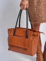 Cartera marrón de cuero sintético con doble asa corta negra y solapa frontal con cierre a presión.