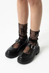 Mocasines negros de cuero con hebilla plateada y suela track.