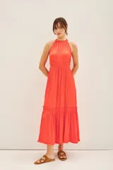 Vestido midi color coral con escote halter, volados en el cuello y ruedo con volado.