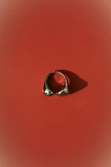 Anillo plateado con diseño orgánico y moderno, compuesto por dos formas abultadas y lisas que se unen en la banda.